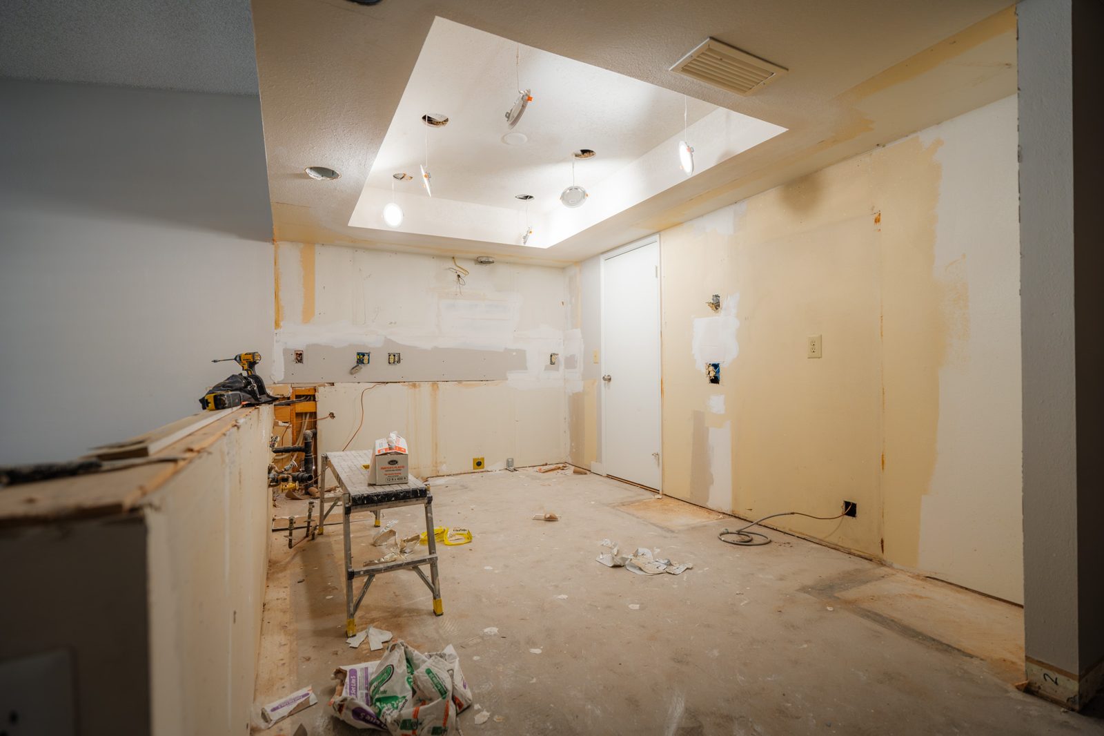 Primary bedroom before — empty room with dark worn carpet and dated paint