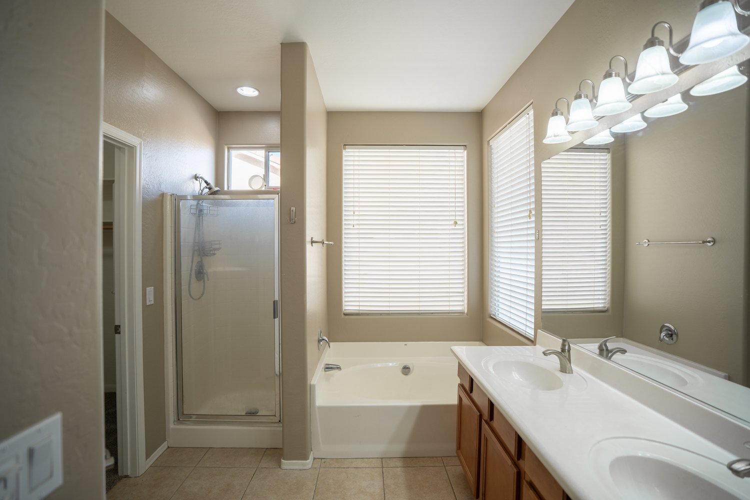 Primary bathroom before — builder-grade shower stall, garden tub and oak vanity